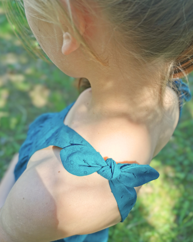 Zoom sur la bretelle à nouer du top Laïa en plumetis, détail de finition du patron couture pour fille.